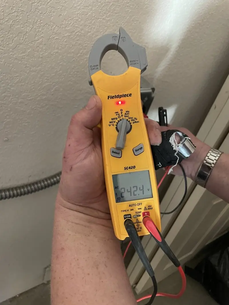 Voltage testing with clamp meter during Outlet Installation in Las Flores